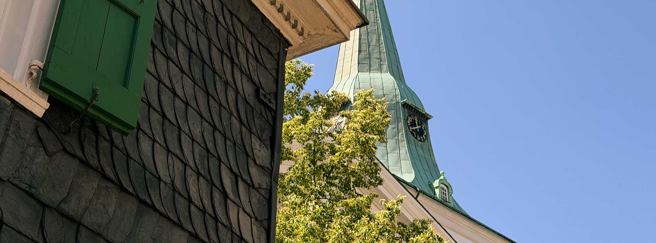 Schieferverkleidetes bergisches Haus mit der Walder Kirche im Hintergrund in Solingen-Wald